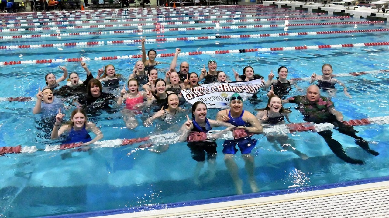 Girls Swim team celebrating in pool after winning 4A State Championship